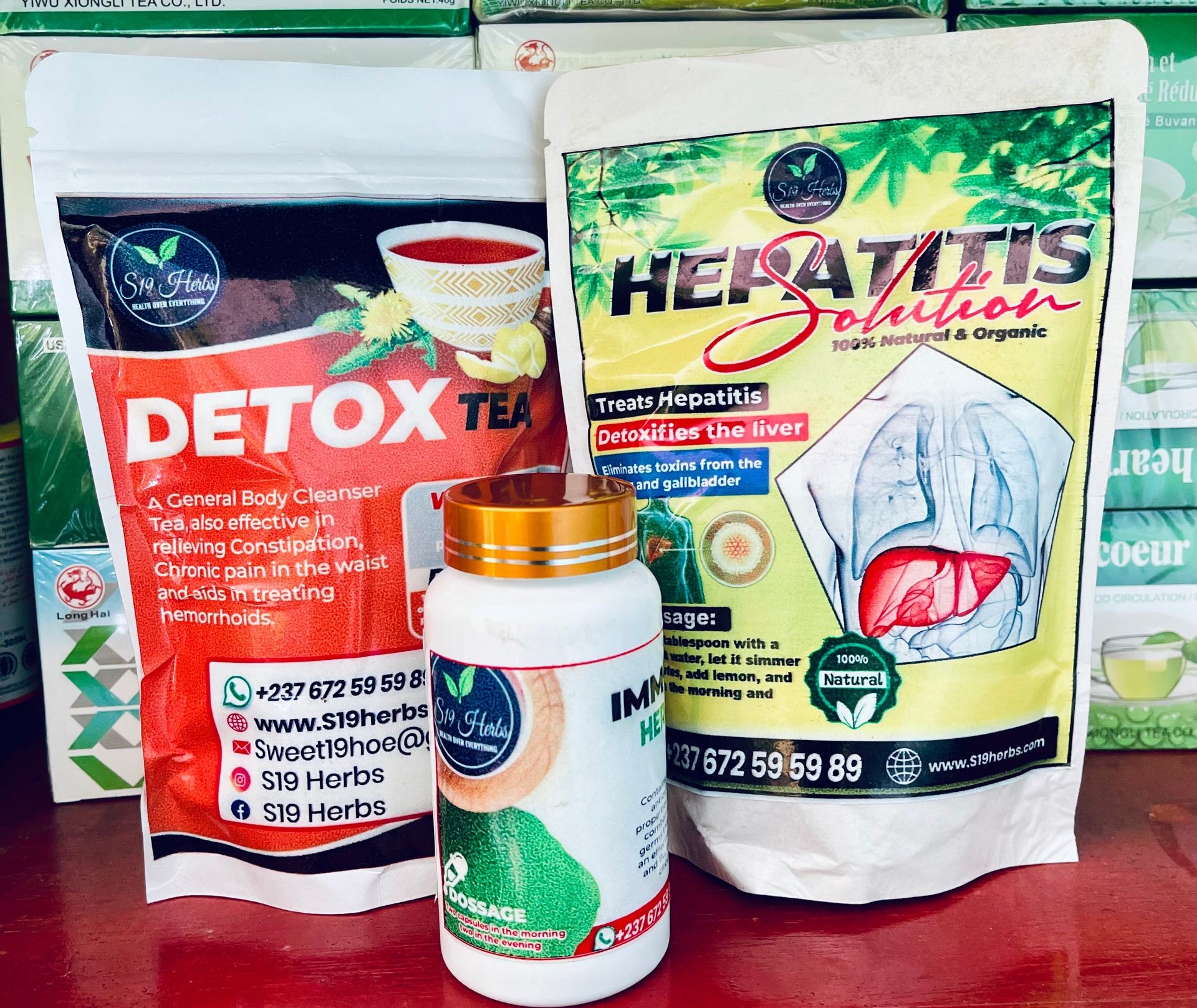 Herbal detox tea, hepatitis solution, and immune herbal supplement packaging on a shelf.